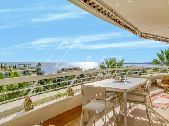 Terrasse d'un appartement avec vue panoramique sur la mer à Cannes, ensoleillée et décorée.