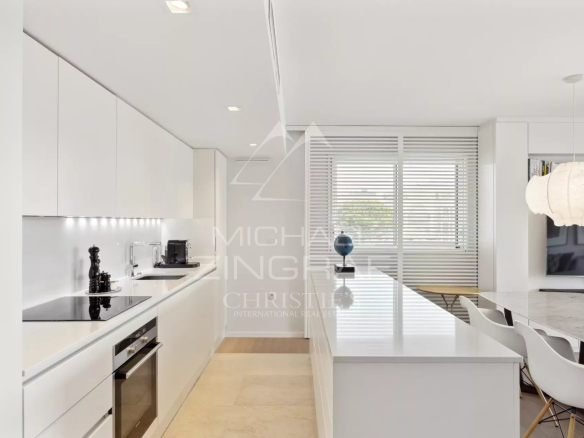 Modern and sleek kitchen in a Cannes apartment, with central island and high-end equipment.