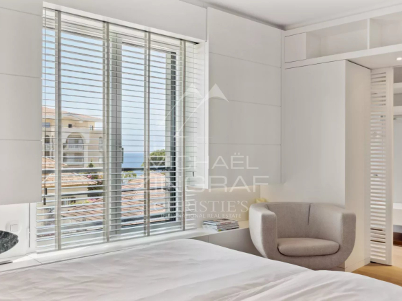 Apartment room in Cannes with shuttered windows and sea view.