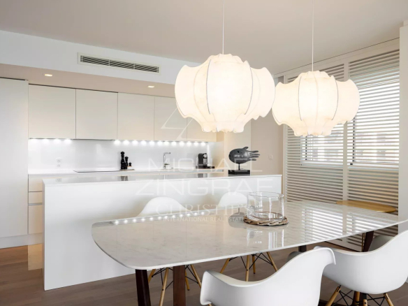 Modern kitchen in a Cannes apartment, with marble table and designer lighting.