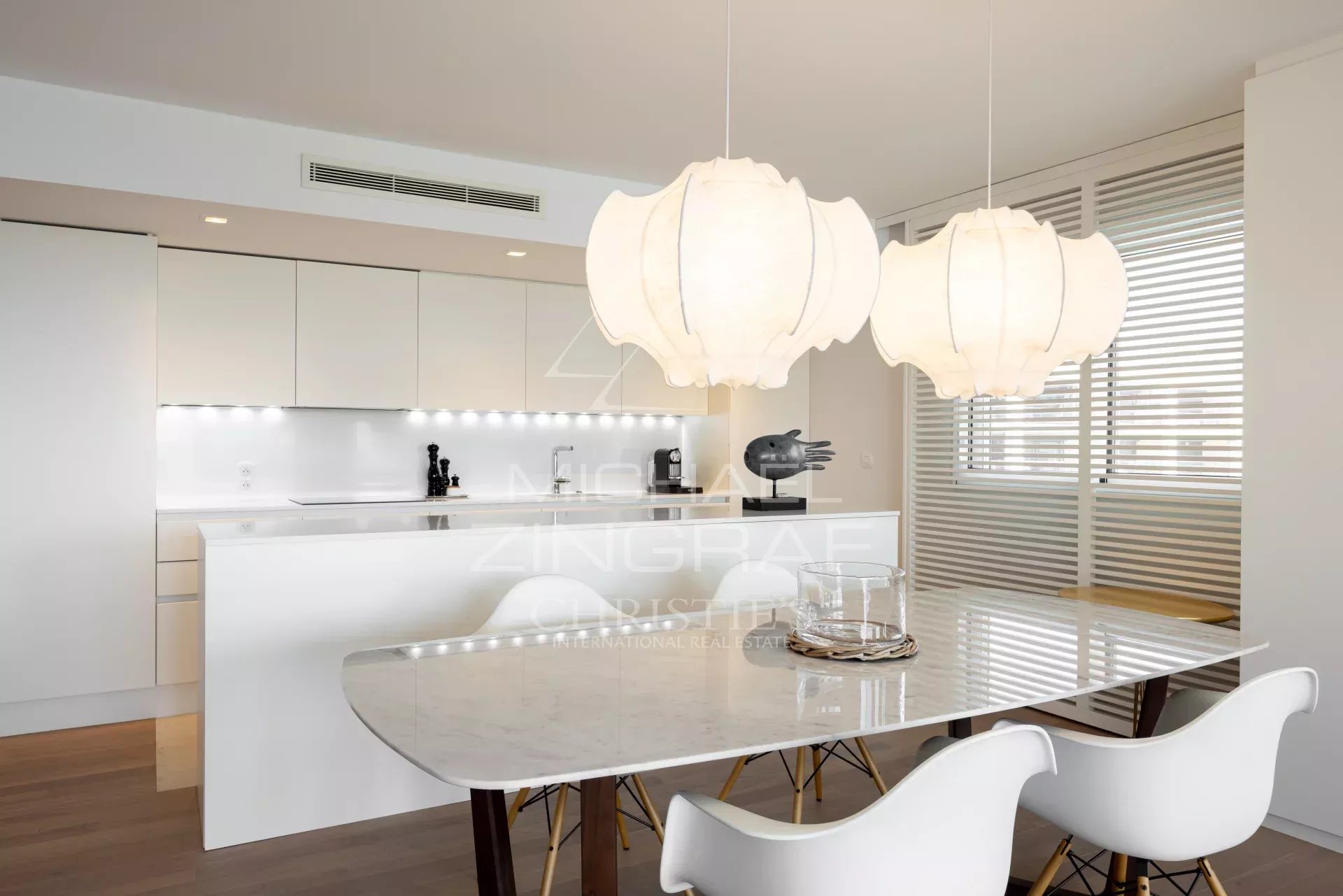 Kitchen of an apartment in Cannes Modern kitchen in a Cannes apartment, with marble table and designer lighting.