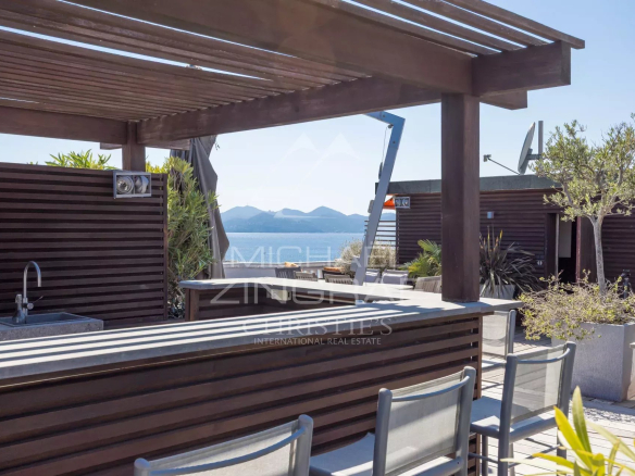 Wooden terrace with bar and chairs, unobstructed view of the sea in Cannes.