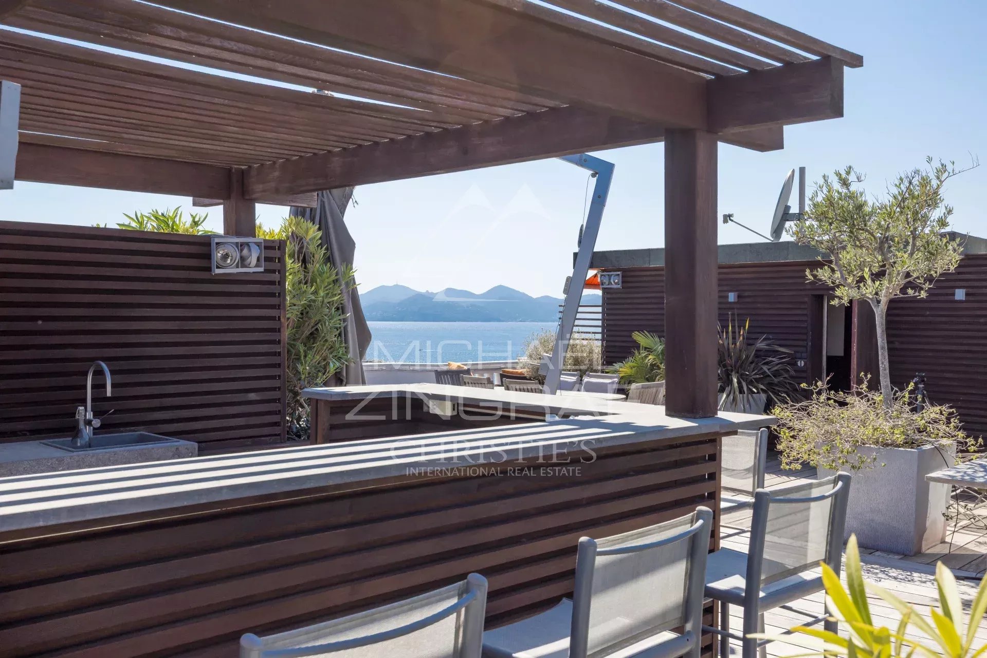 Penthouse with roof terrace in Cannes Wooden terrace with bar and chairs, unobstructed view of the sea in Cannes.