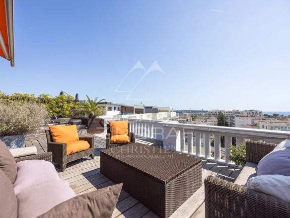 Wooden terrace with garden furniture and sea view in Cannes.