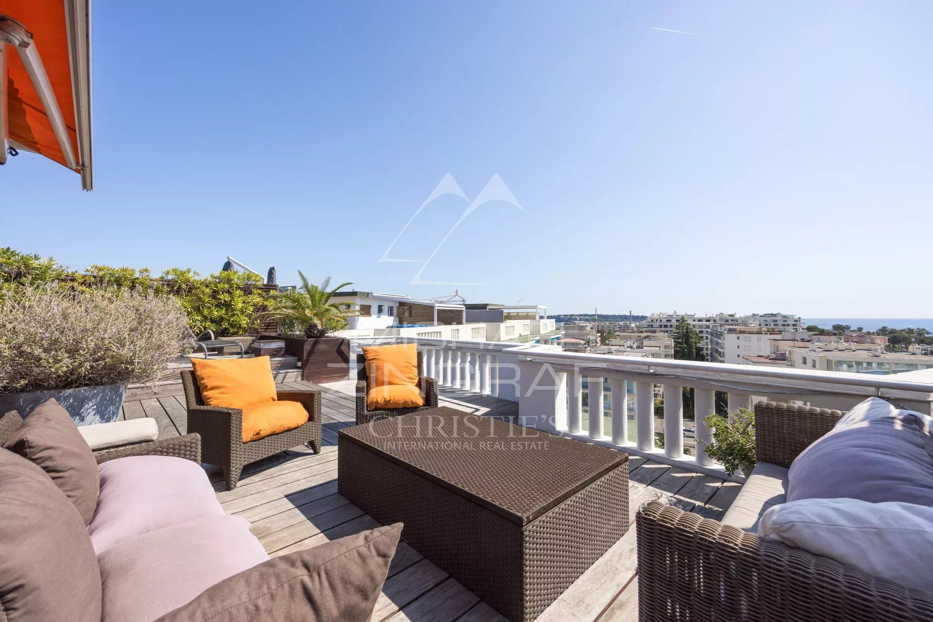 Penthouse with roof terrace in Cannes Wooden terrace with garden furniture and sea view in Cannes.