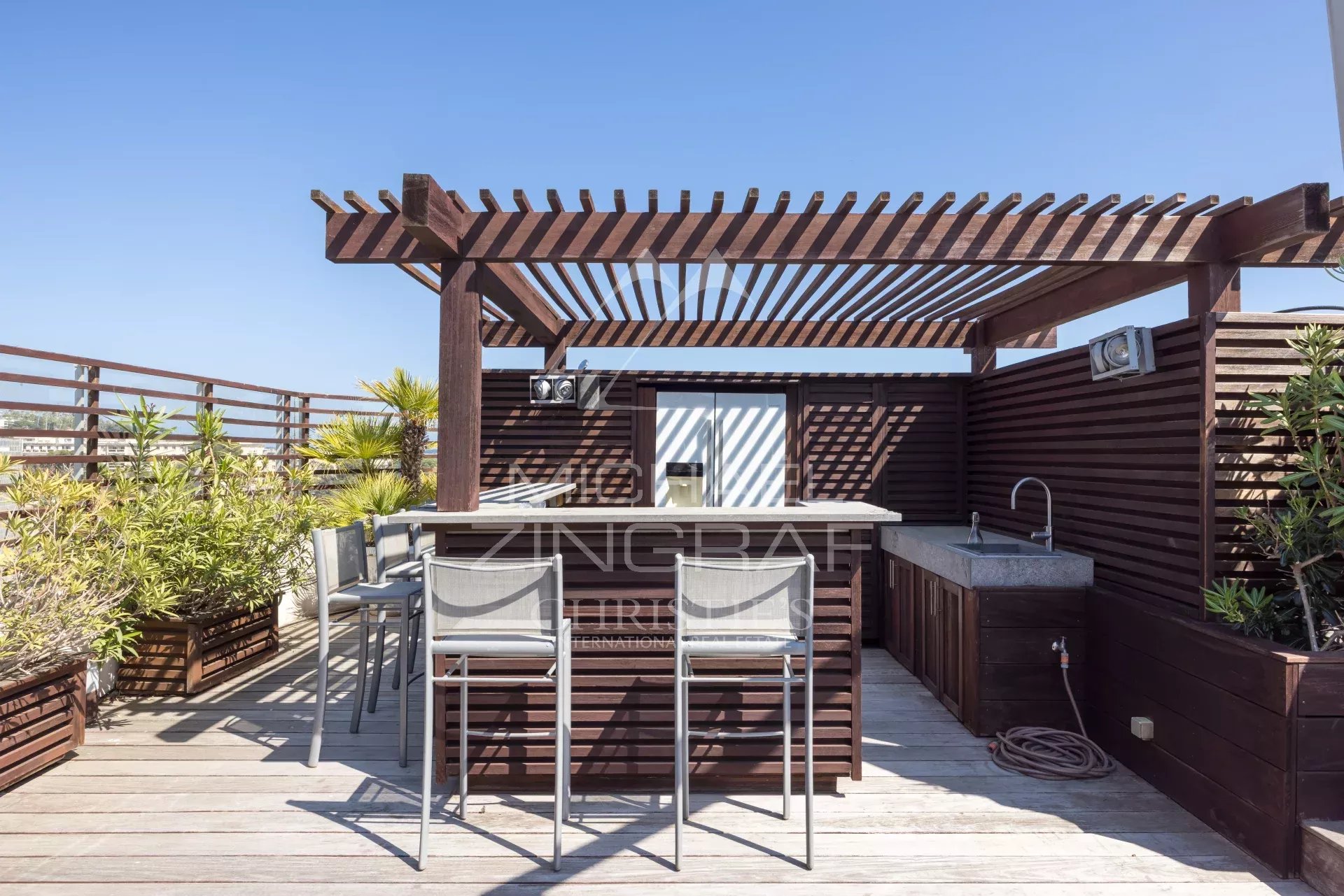 Penthouse with roof terrace in Cannes Wooden terrace with bar and chairs, unobstructed view, sunny.