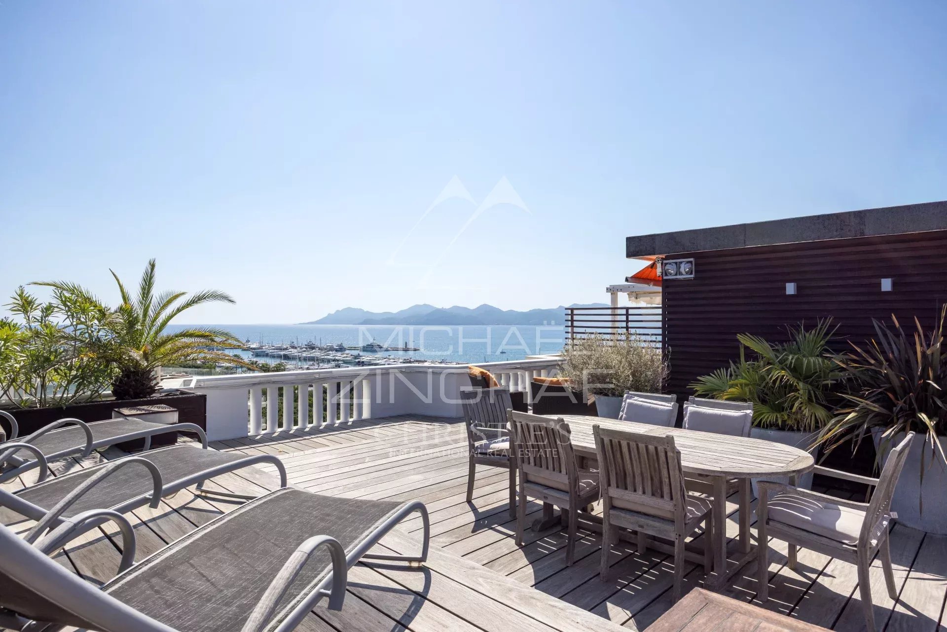 Penthouse with roof terrace in Cannes Wooden terrace with garden furniture and sea view in Cannes.