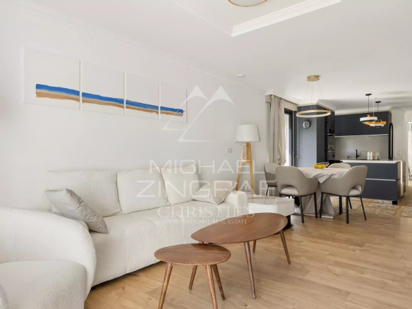 Intérieur d'un appartement rénové à Cannes avec salon, salle à manger et cuisine ouverte.