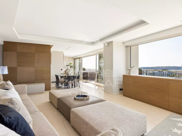 Intérieur d'un penthouse lumineux avec salon moderne et vue sur la mer.