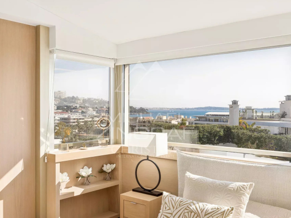 Intérieur lumineux d'un penthouse à Cannes avec vue sur la mer et les îles de Lérins.