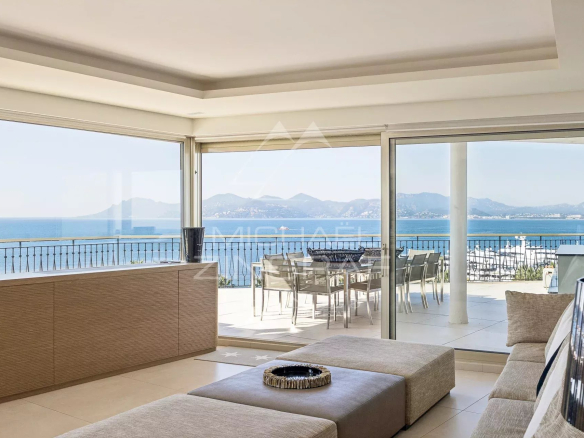 Intérieur d'un penthouse lumineux avec vue sur la mer à Cannes, terrasse panoramique visible.