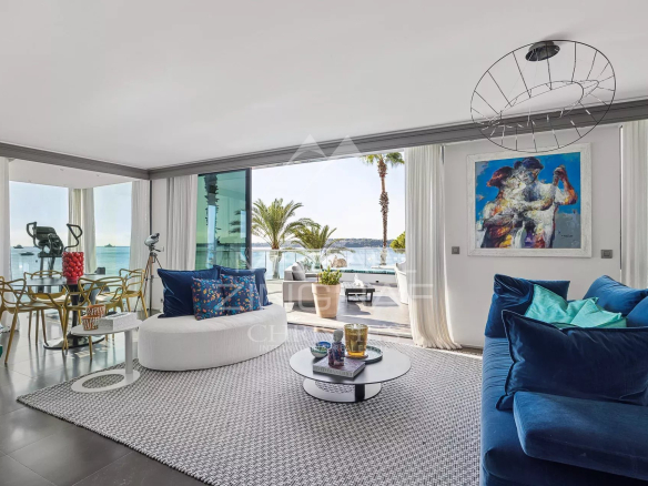 Intérieur d'un triplex moderne avec vue sur la mer, salon lumineux et mobilier contemporain.