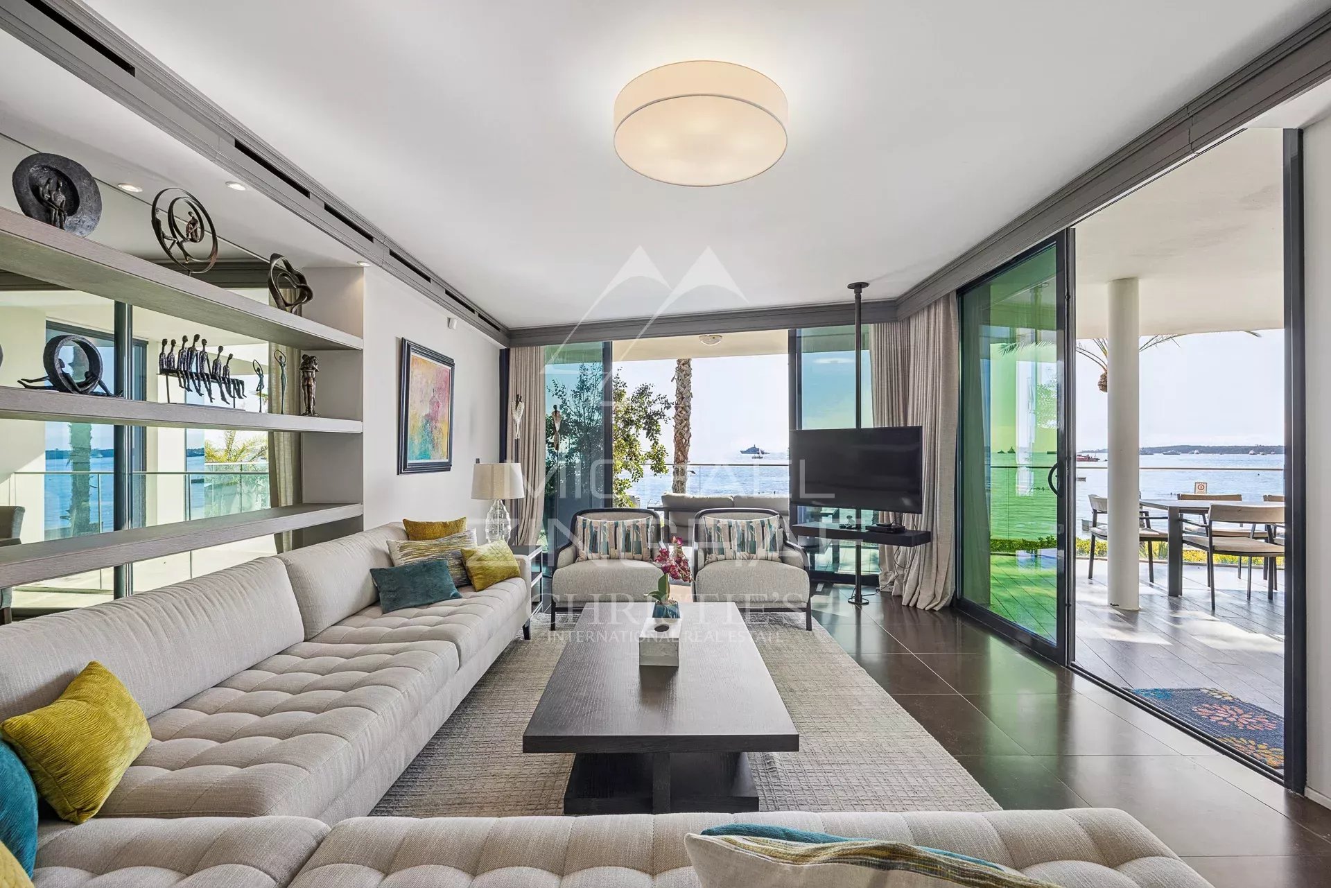 Intérieur d'un triplex moderne avec vue sur la mer à Cannes, salon lumineux et mobilier contemporain.