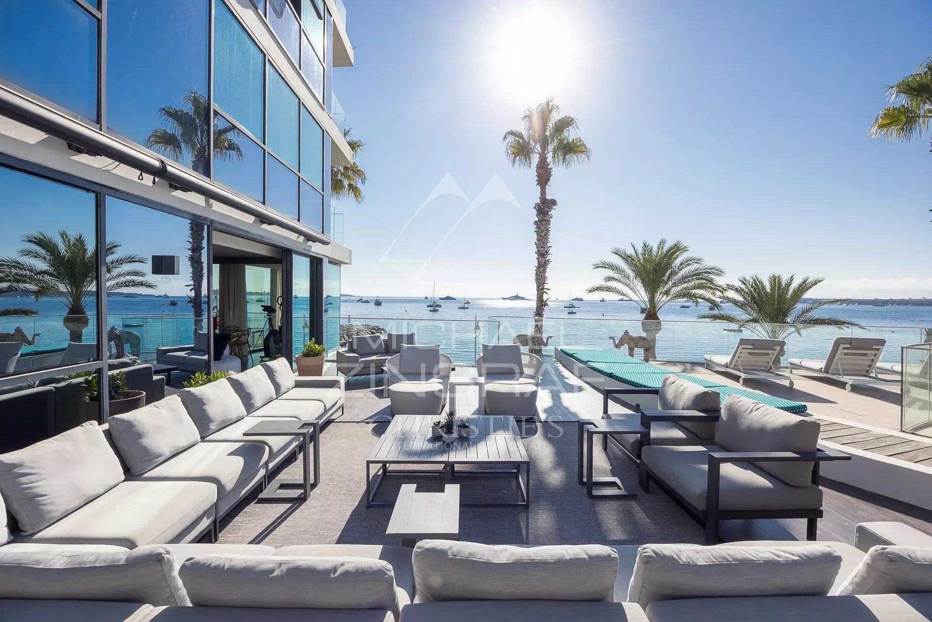 Terrasse d'un triplex en front de mer à Cannes avec vue sur la mer et les palmiers.