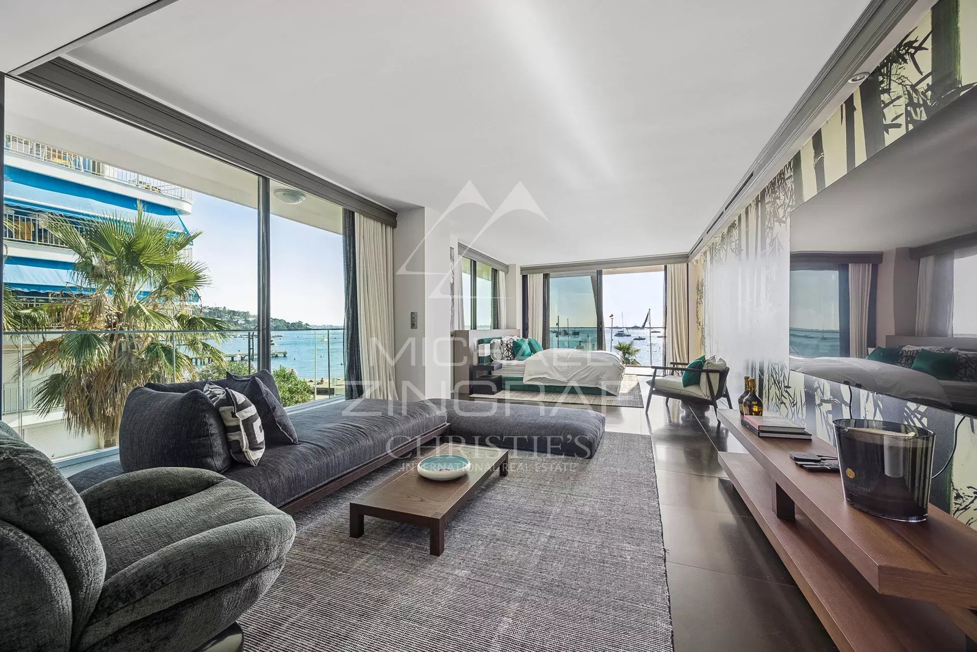 Intérieur d'un triplex moderne avec vue sur la mer à Cannes, salon lumineux et mobilier contemporain.