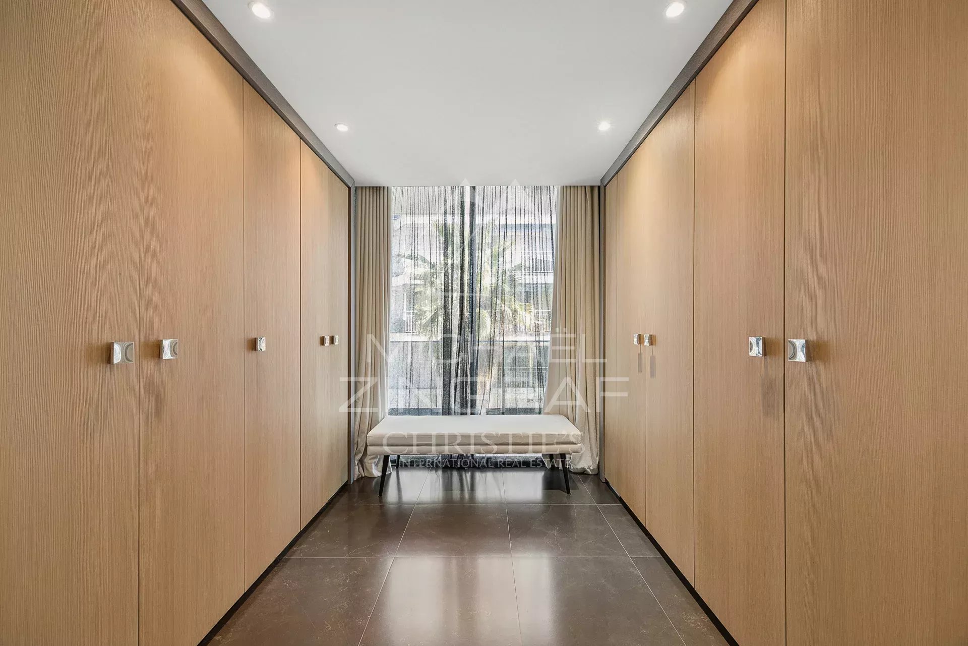 Intérieur d'un triplex à Cannes avec placards en bois et accès à une terrasse.