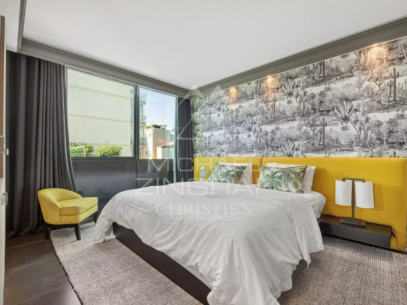 Chambre d'un triplex moderne avec un lit jaune et une vue sur l'extérieur.