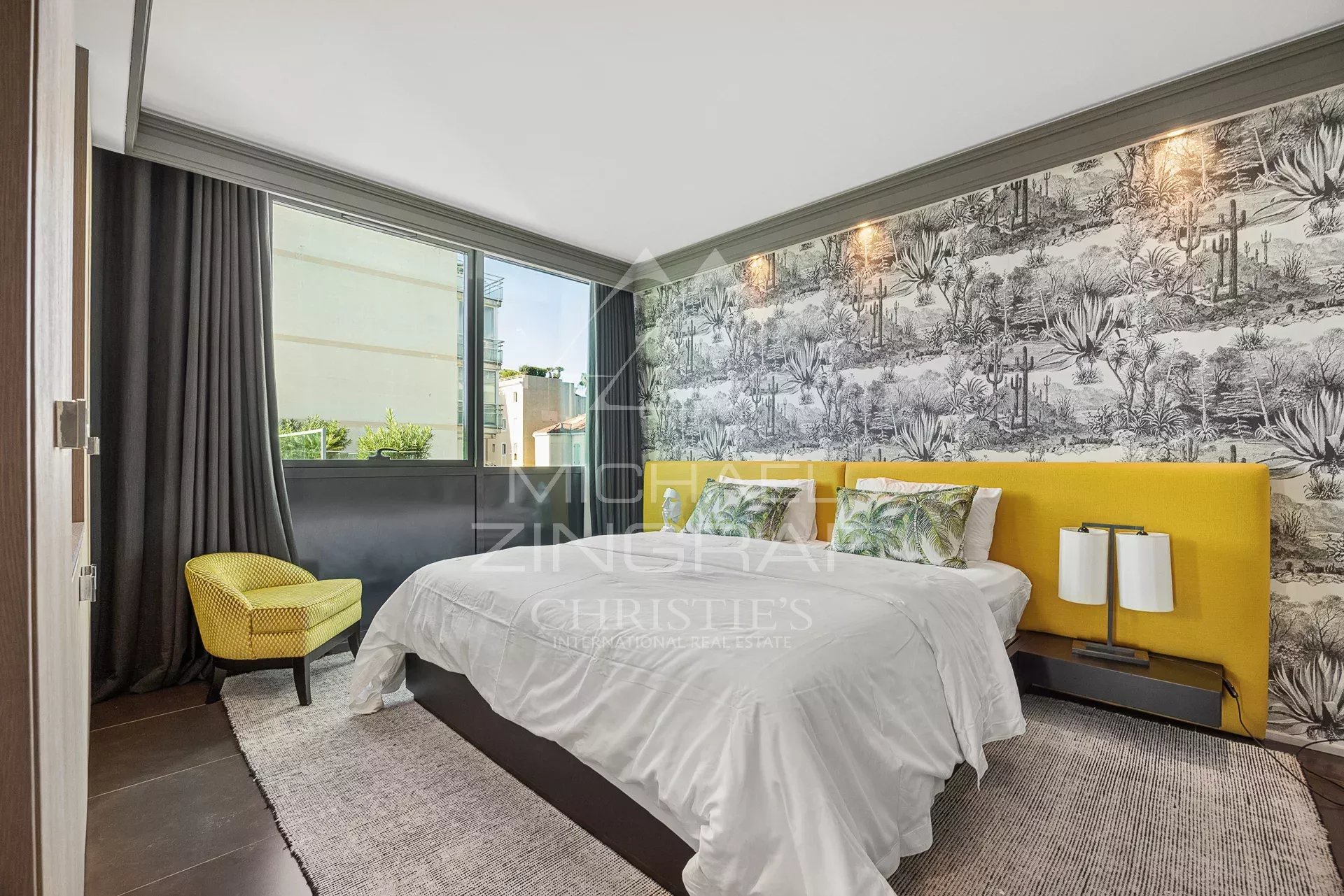 Chambre d'un triplex moderne avec un lit jaune et une vue sur l'extérieur.