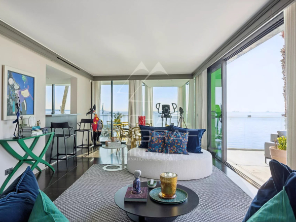 Intérieur d'un triplex moderne avec vue sur la mer à Cannes, comprenant un salon lumineux et des baies vitrées.