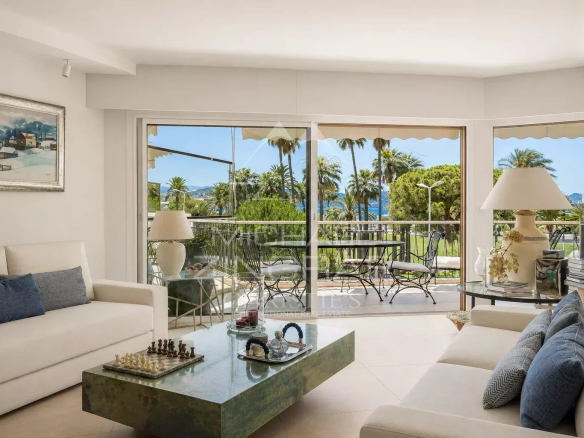 Salon lumineux d'un appartement à Cannes avec vue sur la mer et la Croisette.