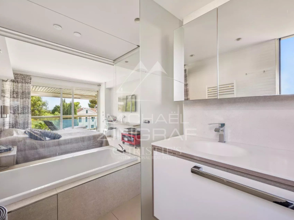 Salle de bain moderne avec baignoire et vue sur un séjour lumineux à Cannes Palm Beach.