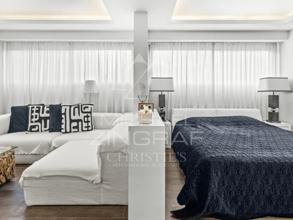 Studio moderne et spacieux avec canapé et lit, décoré en blanc et bleu, dans une résidence de luxe à Cannes.