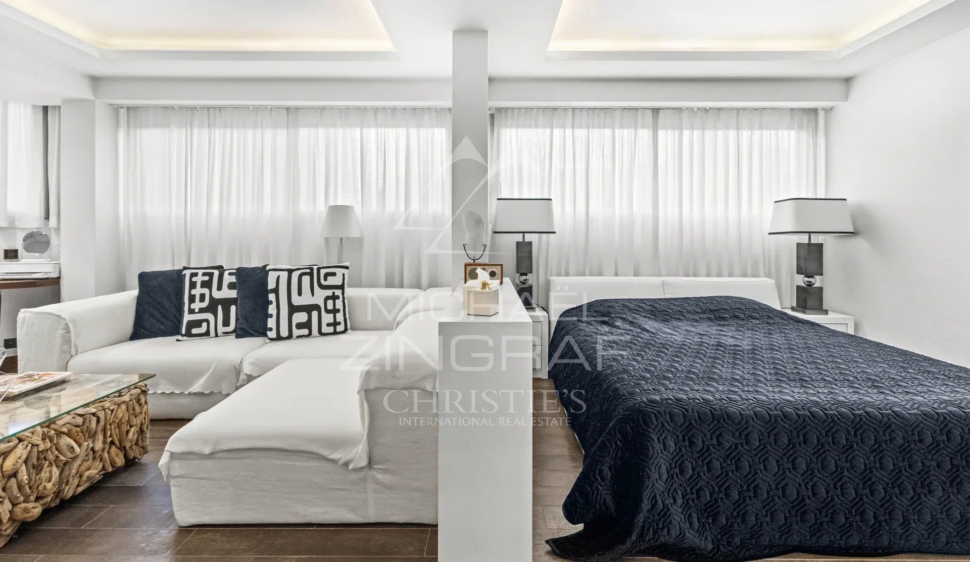 Studio d’exception à Cannes Studio moderne et spacieux avec canapé et lit, décoré en blanc et bleu, dans une résidence de luxe à Cannes.
