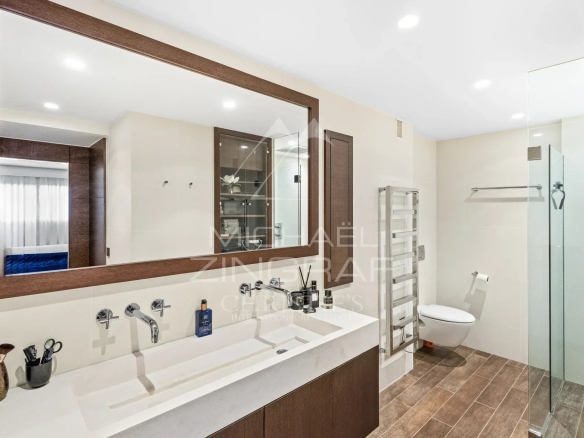 Salle de bain moderne avec double vasque et douche à l'italienne dans un studio à Cannes.