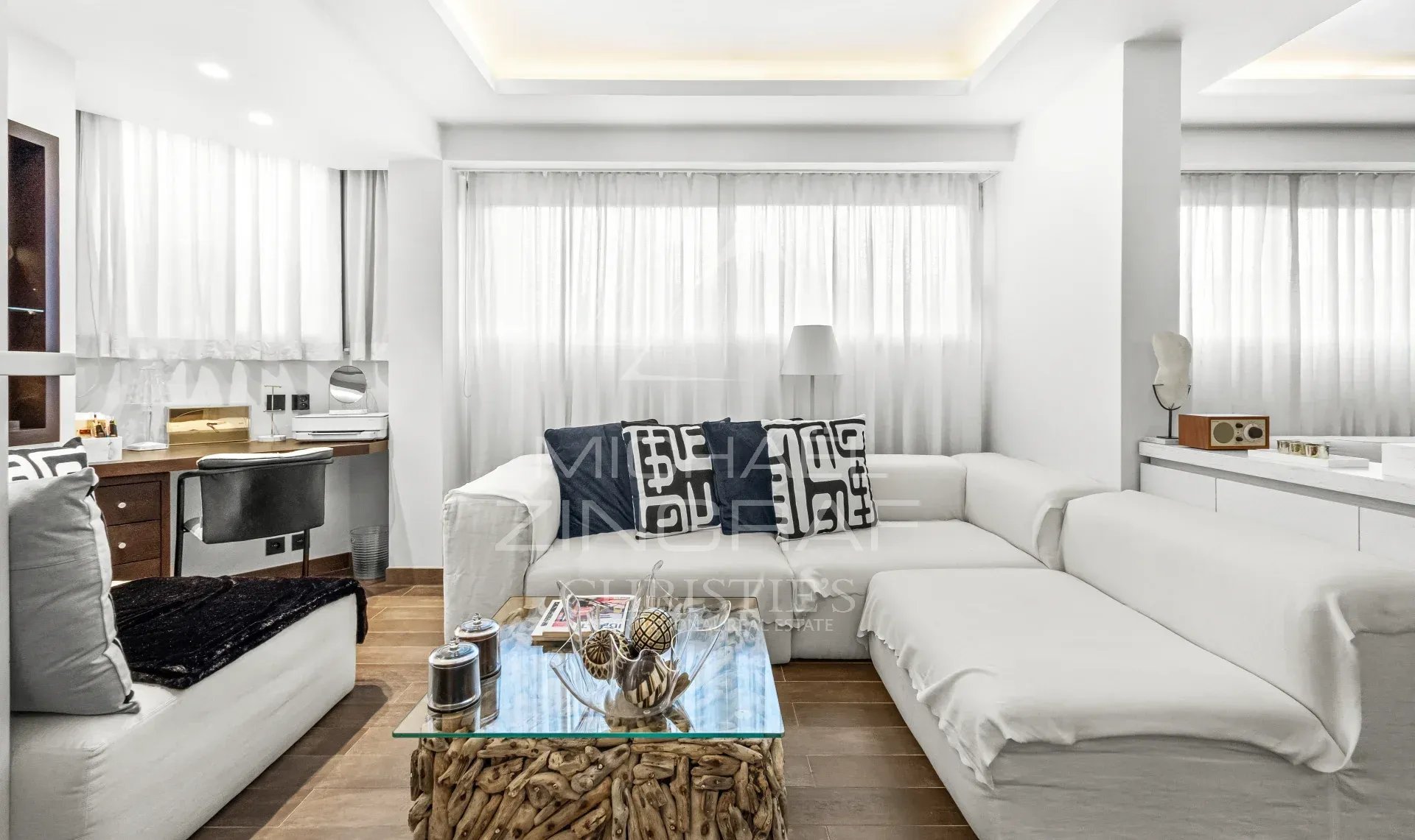 Studio d’exception à Cannes Intérieur d'un studio moderne et spacieux avec un canapé blanc et des rideaux clairs.