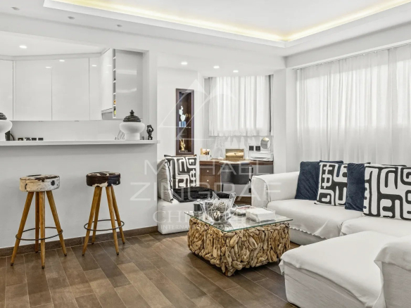 Intérieur d'un studio rénové de 53 m² à Cannes, avec salon lumineux et cuisine semi-ouverte.