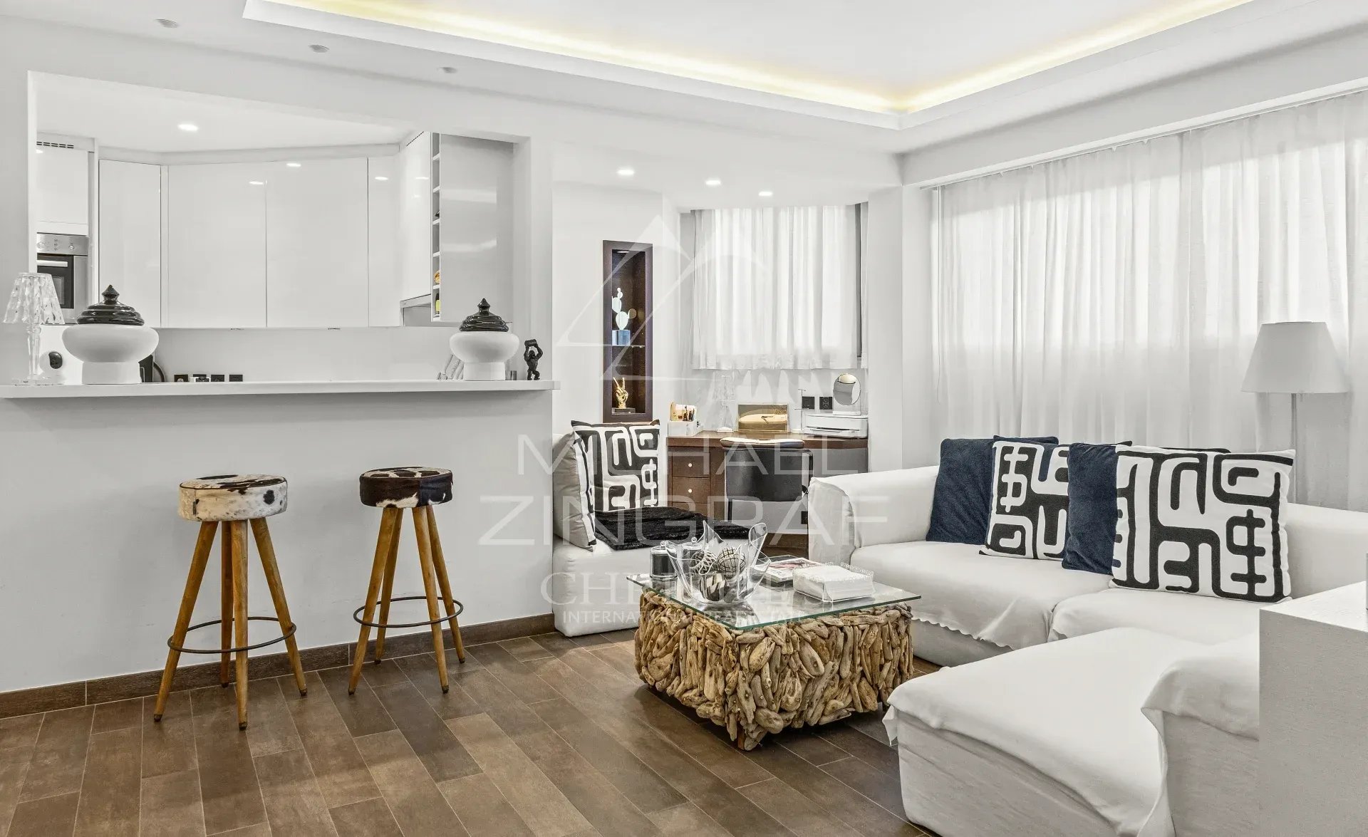 Studio d’exception à Cannes Intérieur d'un studio rénové de 53 m² à Cannes, avec salon lumineux et cuisine semi-ouverte.