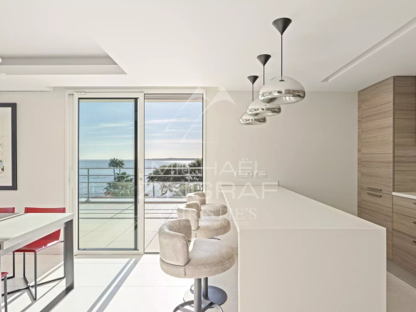 Intérieur d'une villa sur le toit à Cannes avec vue sur la mer, cuisine moderne et salle à manger.