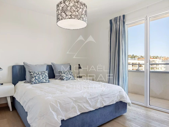 Chambre d'une villa sur le toit à Cannes avec lit double et accès à un balcon.