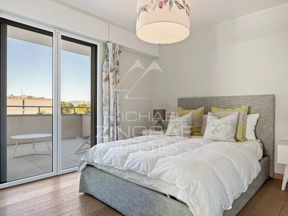 Chambre d'une villa sur le toit à Cannes, avec lit et accès à un balcon.