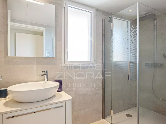 Salle de bain moderne avec douche et lavabo dans une villa sur le toit à Cannes.