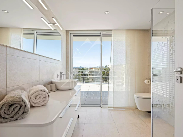 Salle de bain moderne avec baignoire et douche, vue sur l'extérieur à Cannes.