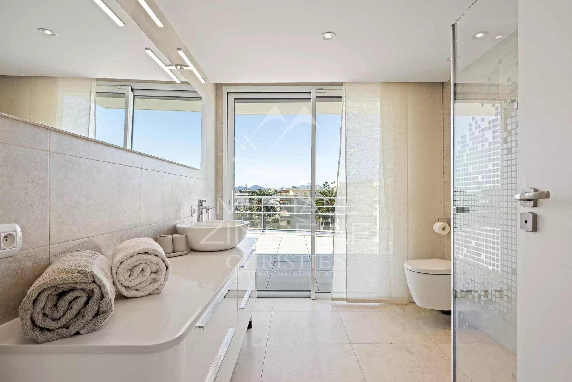 Salle de bain contemporaine à Cannes Salle de bain moderne avec baignoire et douche, vue sur l'extérieur à Cannes.