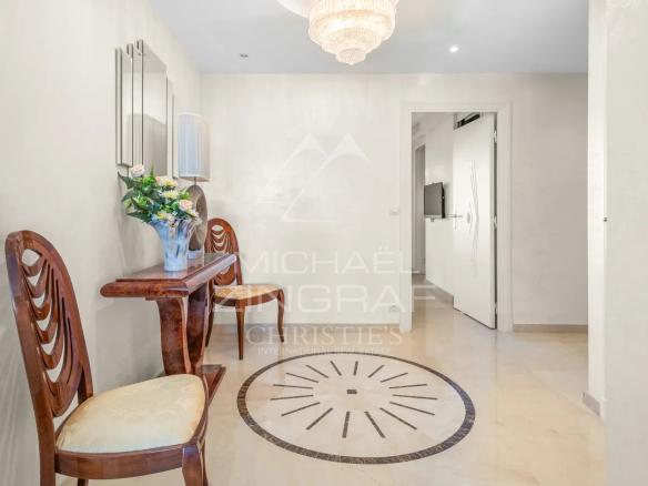 Hall d'entrée d'un appartement à Cannes, avec deux chaises et une décoration élégante.