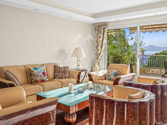 Salon d'un appartement de luxe à Cannes avec vue sur la mer et mobilier élégant.
