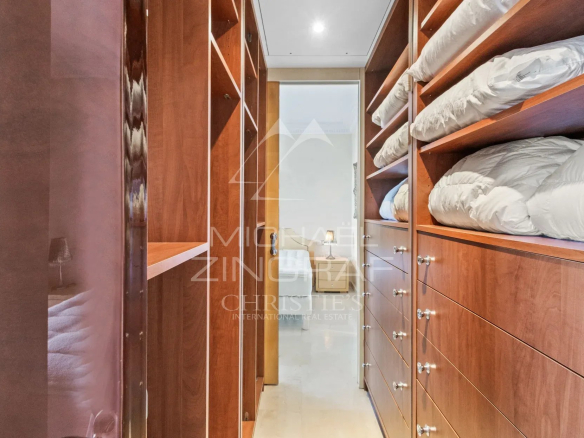 Intérieur d'un appartement avec des placards en bois et du linge plié.