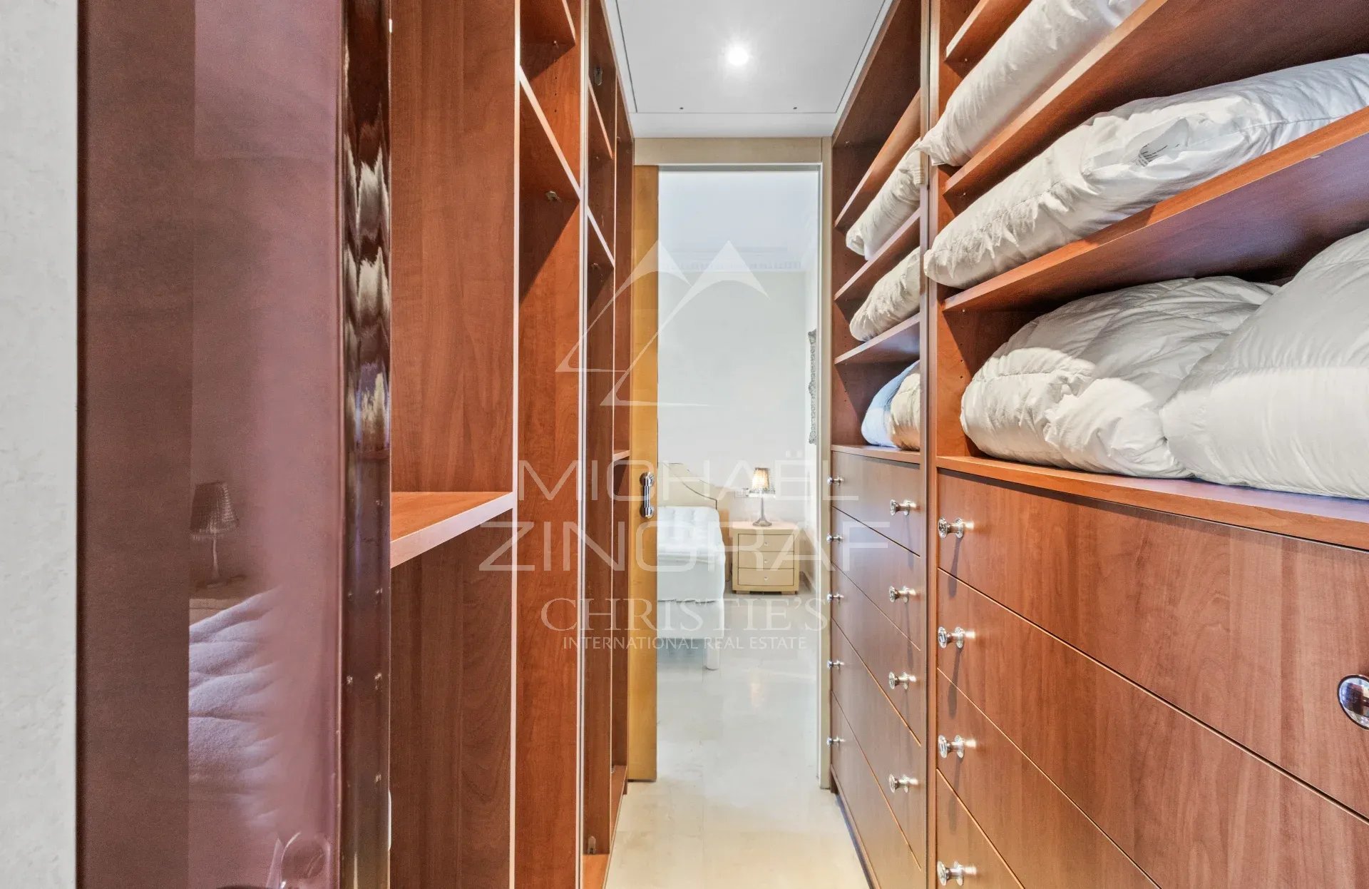 Intérieur d’un appartement à Cannes Intérieur d'un appartement avec des placards en bois et du linge plié.