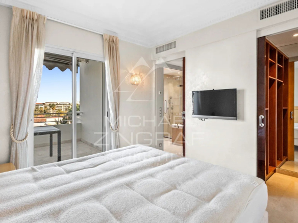 Chambre d'un appartement à Cannes avec lit et accès à un balcon.