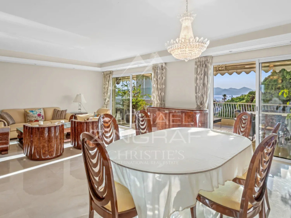 Intérieur d'un appartement de luxe à Cannes avec salle à manger et vue sur la mer.