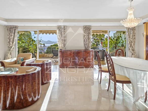 Intérieur d'un appartement de luxe à Cannes avec vue sur la mer, salon et salle à manger.