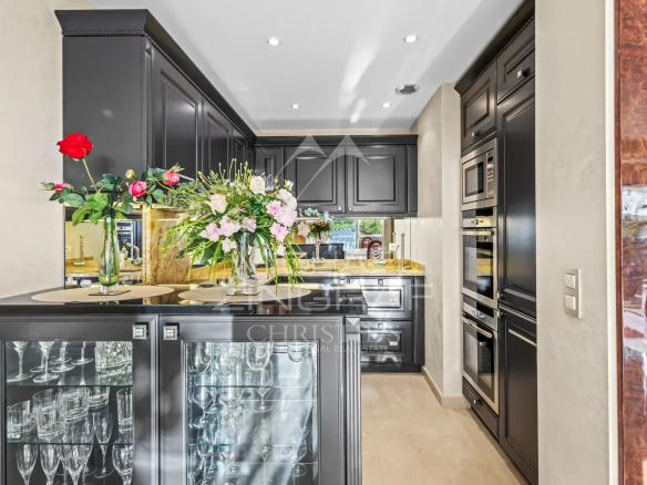 Cuisine moderne avec meubles noirs et fleurs, appartement à Cannes