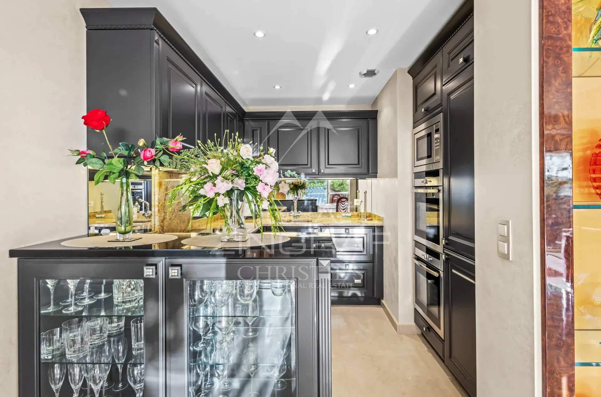 Cuisine d’un appartement à Cannes Cuisine moderne avec meubles noirs et fleurs, appartement à Cannes