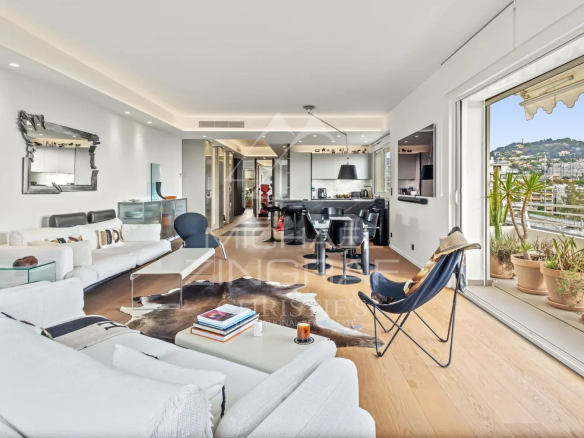 Intérieur d'un appartement rénové à Cannes avec un salon moderne et vue sur la mer.