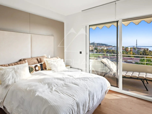 Chambre d'un appartement rénové à Cannes avec vue sur la mer et accès à une terrasse.