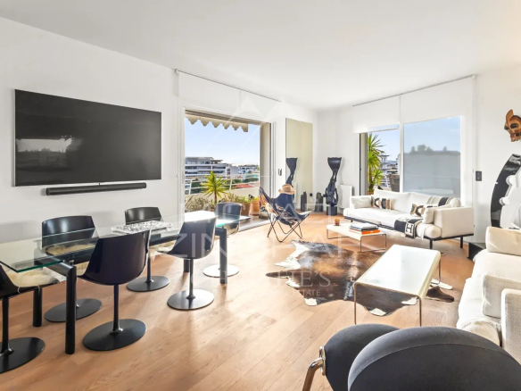 Intérieur d'un appartement rénové avec salon, salle à manger et grandes fenêtres à Cannes.