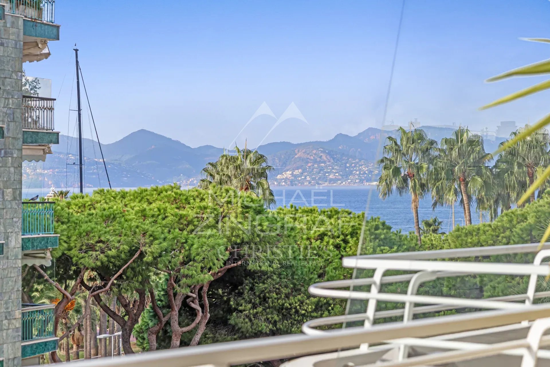 Vue depuis un appartement à Cannes Vue depuis une terrasse d'un appartement à Cannes, avec mer et montagnes en arrière-plan.